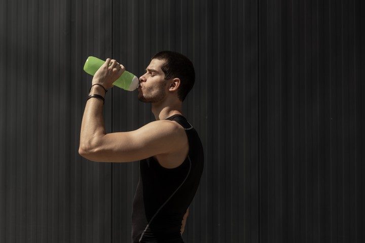 portrait muscular man taking a break to hydrate his body after