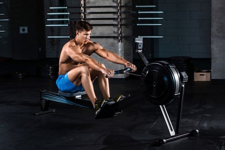 muscular man doing exercise for legs in the gym