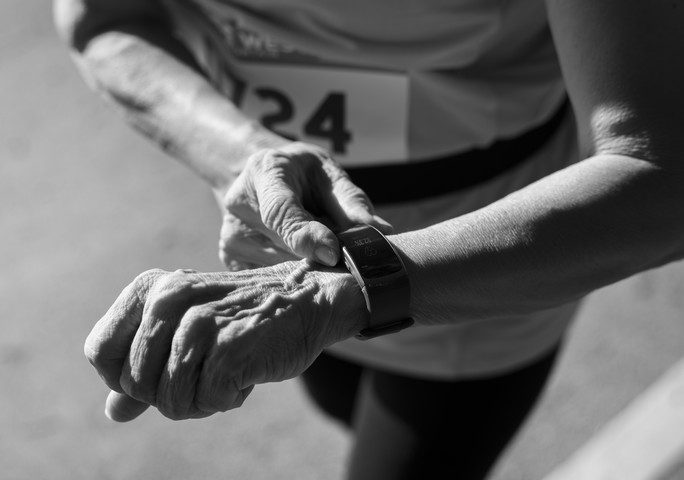 senior runner using a fitness tracker